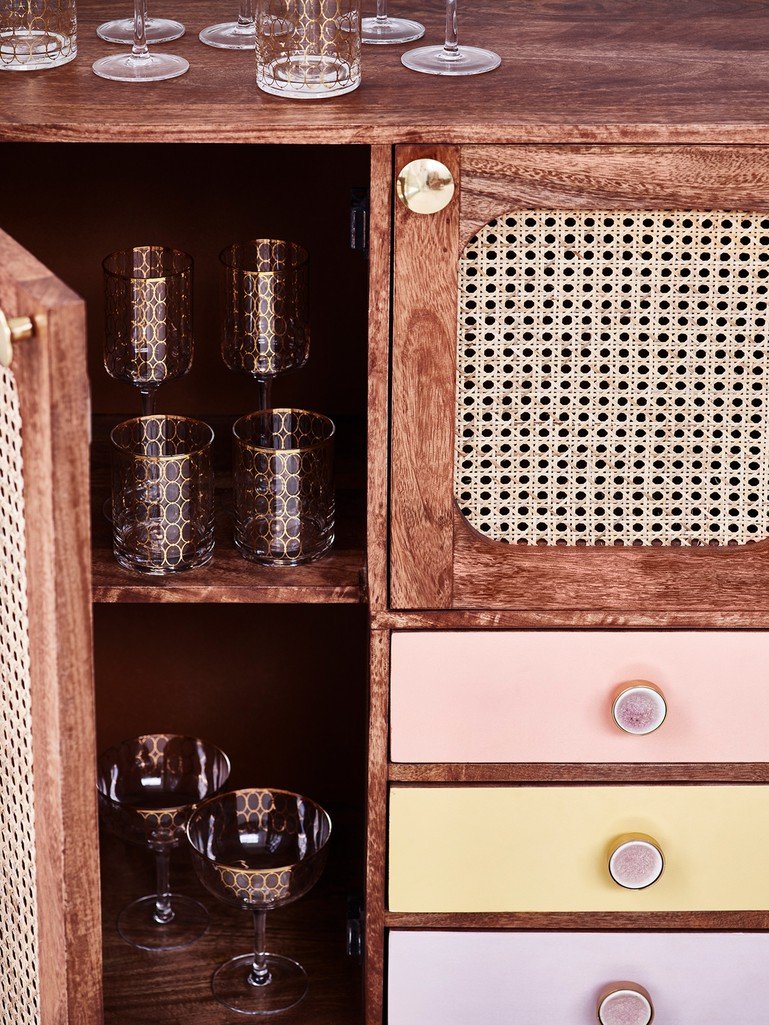 Wooden cabinet with glassware and colorful drawers